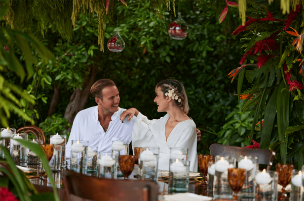 tropical wedding attire on couple sitting at reception table